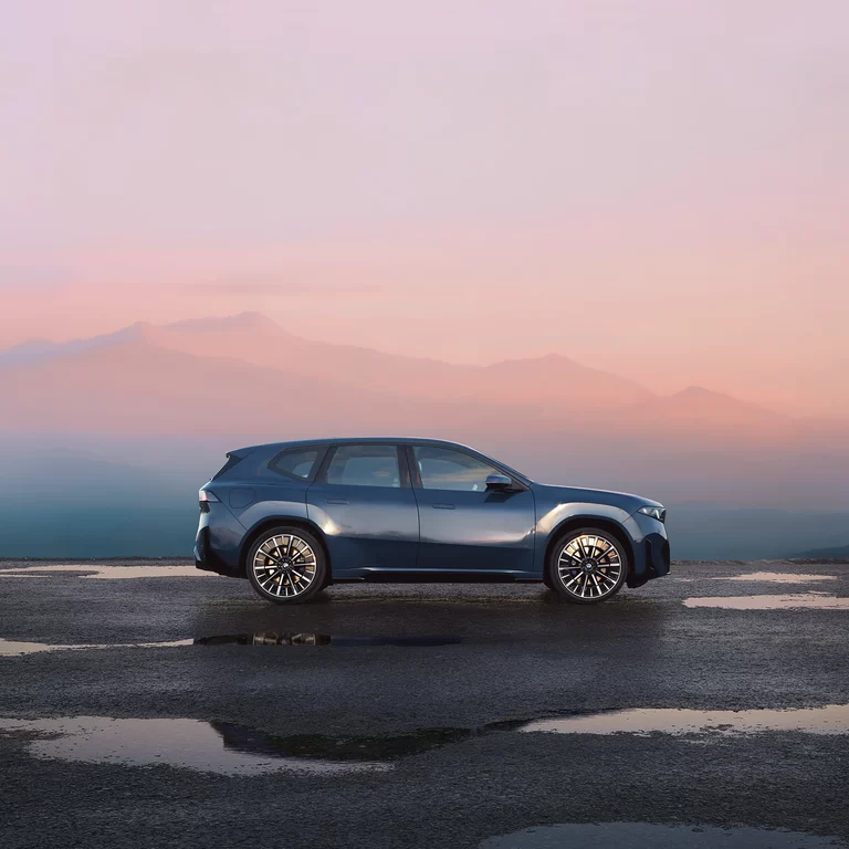 BMW iX3 Neue Klasse – Seitenansicht bei Sonnenuntergang BMW iX3 Neue Klasse Seitenansicht in Fahrdynamikaufnahme