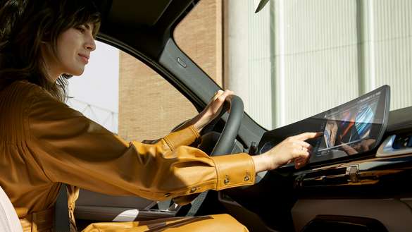 Fahrerin bedient das Zentraldisplay im Innenraum eines BMW X1 Eine Fahrerin bedient das Zentraldisplay im Innenraum eines BMW X1.