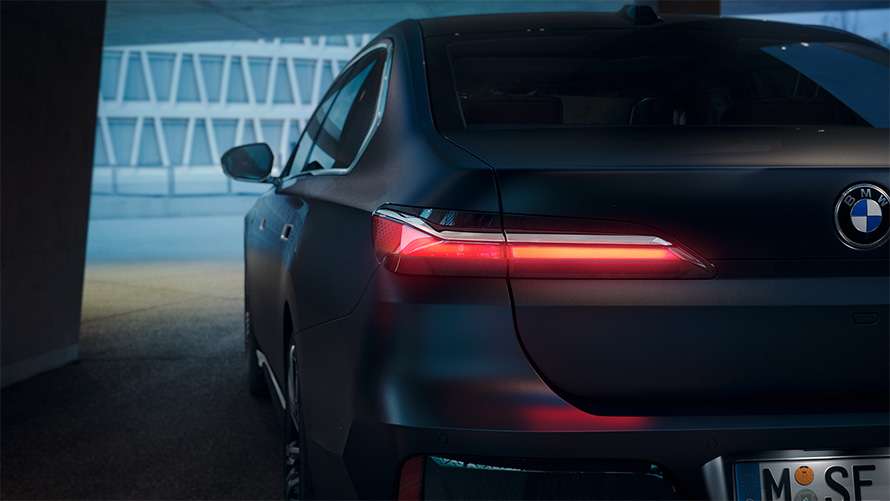 Schmale rote LED-Rückleuchte und Heckpartie einer dunklen BMW 7er Limousine Schmale rote LED-Rückleuchte und Heckpartie einer dunklen BMW 7er Limousine.