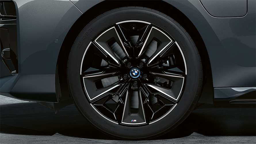Schwarz-silbernes Leichtmetallrad mit M-Emblem an einer grauen BMW 7er Limousine Schwarz-silbernes Leichtmetallrad mit M-Emblem an einer grauen BMW 7er Limousine.