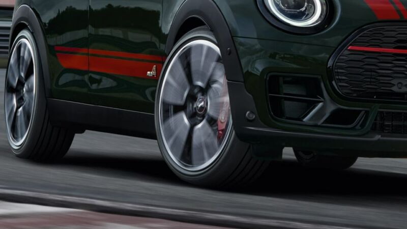 MINI John Cooper Works – Fahrwerk Vorderrad und Frontpartie eines dunkelgrünen MINI während der Fahrt.