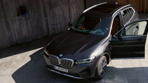 Dunkler BMW X3 mit geöffneter Fahrertür Dunkler BMW X3 mit geöffneter Fahrertür, schräg von oben vor einer Betonwand.